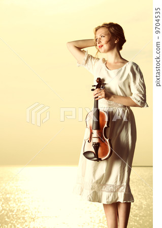 The blonde girl with a violin outdoor The blonde girl with a violin outdoor 9704535