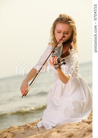 The blonde girl with a violin outdoor The blonde girl with a violin outdoor 9704558