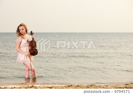 The blonde girl with a violin outdoor The blonde girl with a violin outdoor 9704571