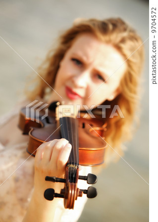 Portrait blonde girl with a violin outdoor 9704572