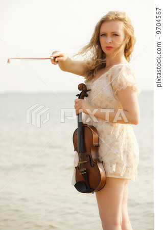 The blonde girl with a violin outdoor The blonde girl with a violin outdoor 9704587