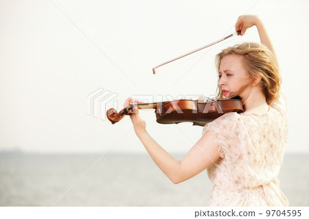 The blonde girl with a violin outdoor The blonde girl with a violin outdoor 9704595