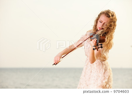 The blonde girl with a violin outdoor The blonde girl with a violin outdoor 9704603