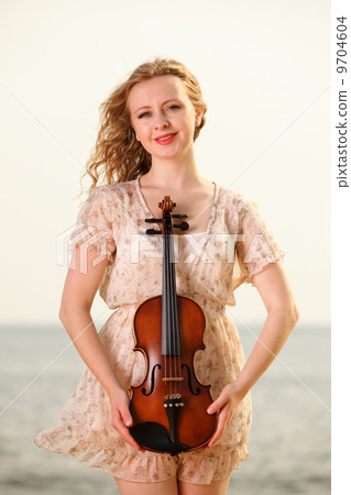 The blonde girl with a violin outdoor The blonde girl with a violin outdoor 9704604