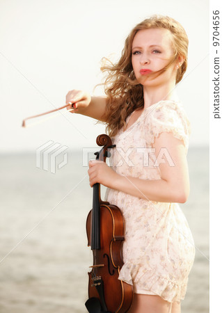 The blonde girl with a violin outdoor The blonde girl with a violin outdoor 9704656