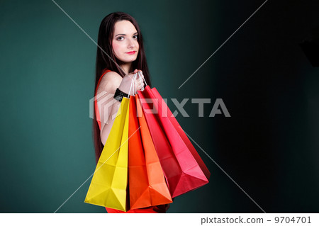 young woman with paper multi coloured shopping bag 9704701
