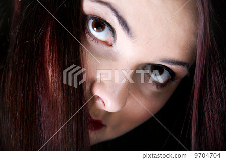 Woman covers part of face by straight long hair 9704704