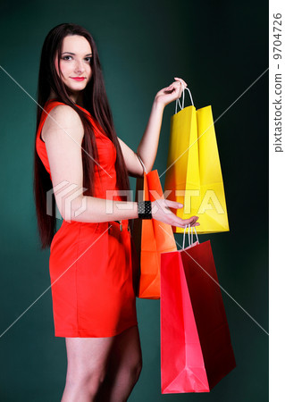 young woman with paper multi coloured shopping bag 9704726