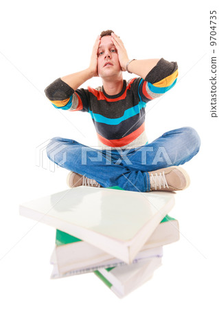 Exhausted tired college student with pile of books studying for exam 9704735