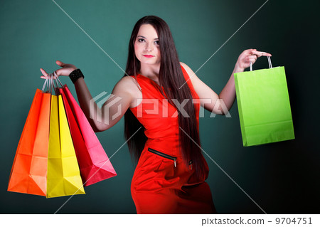 young woman with paper multi coloured shopping bag 9704751