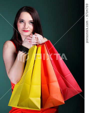 young woman with paper multi coloured shopping bag 9704769