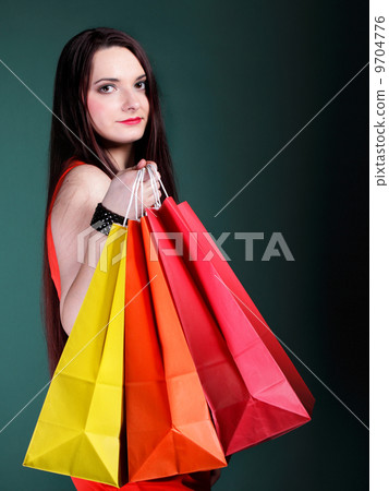 young woman with paper multi coloured shopping bag 9704776