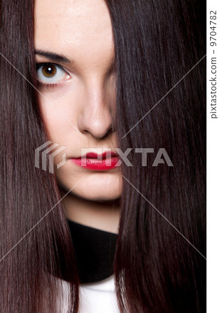 Woman covers part of face by straight long hair 9704782