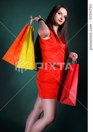 young woman with paper multi coloured shopping bag 9704793