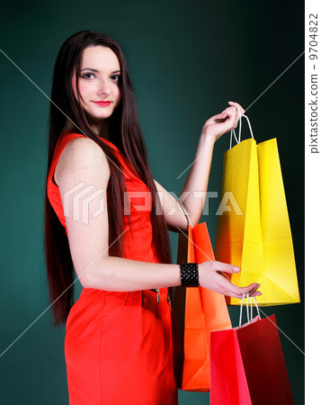 young woman with paper multi coloured shopping bag 9704822