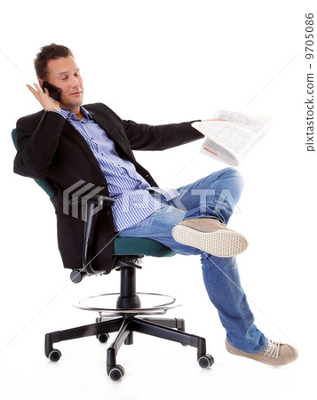 young businessman reads newspaper while phoning young businessman reads newspaper while phoning 9705086