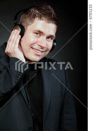 young man with headphones listening to music young man with headphones listening to music 9705235