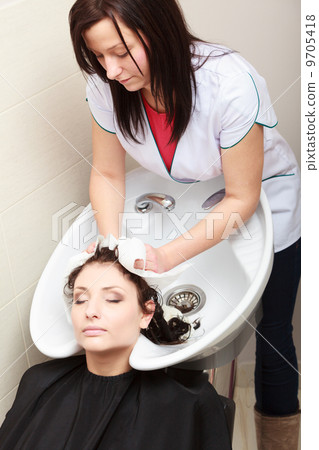 Hairstylist washing woman hair. Hairdressing beauty salon 9705418