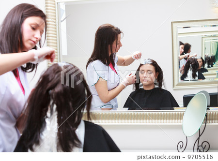hairdresser applying color female customer at salon, doing hair dye 9705516