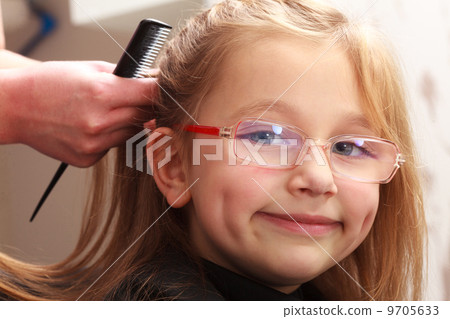 Hairdresser combing hair little girl child in hairdressing beauty salon Hairdresser combing hair little girl child in hairdressing beauty salon 9705633
