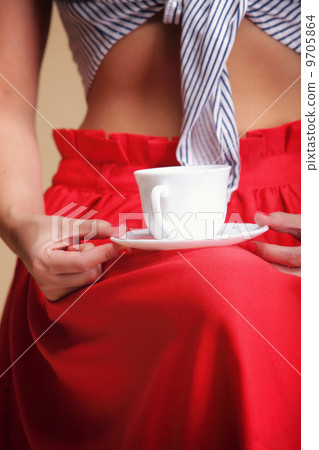 Woman holding tea or coffee cup 9705864