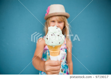 Ice cream cone held by young girl Ice cream cone held by young girl 9719017