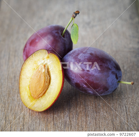 ripe plums on old wood table 9722607