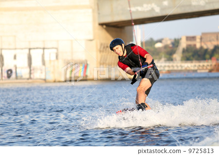 Wakeboarder surfing across a river 9725813