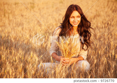 Beautiful brunette lady in wheat field at sunset 9726770