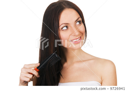 Beautiful young woman combing her hair 9726941