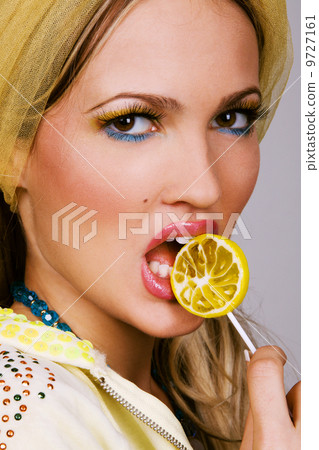 Fashionable young woman holding a candy Fashionable young woman holding a candy 9727161