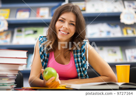Beautiful female student in a library Beautiful female student in a library 9727164