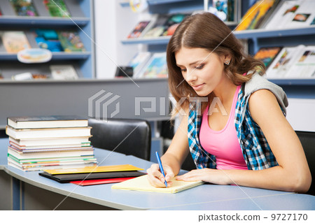 Beautiful female student in a library Beautiful female student in a library 9727170