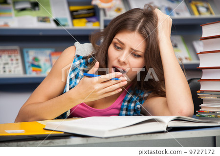 Beautiful female student in a library Beautiful female student in a library 9727172