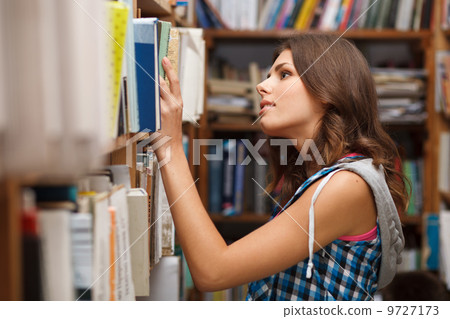 Beautiful female student in a library Beautiful female student in a library 9727173