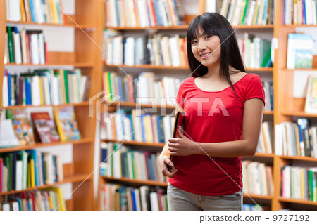 Beautiful female student in a library 9727192
