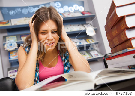 Stressed female student in a library Stressed female student in a library 9727198