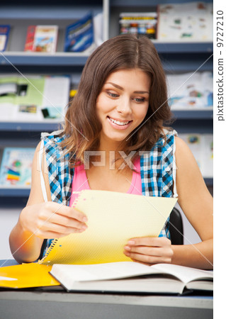 Beautiful female student in a library Beautiful female student in a library 9727210
