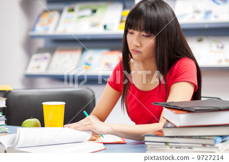 Beautiful female student in a library Beautiful female student in a library 9727214