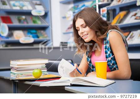 Beautiful female student in a university library Beautiful female student in a university library 9727219