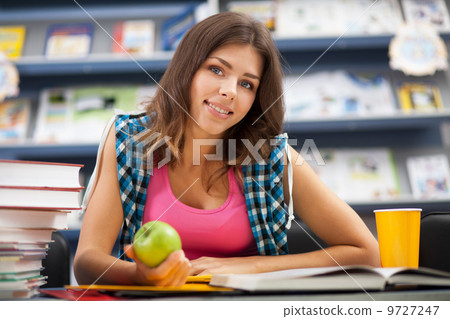 Beautiful female student in a university library Beautiful female student in a university library 9727247