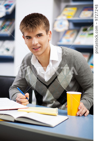 Handsome male student in a university library Handsome male student in a university library 9727248