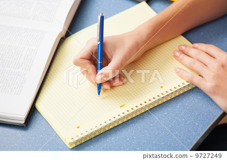 Woman writing in a note pad Woman writing in a note pad 9727249