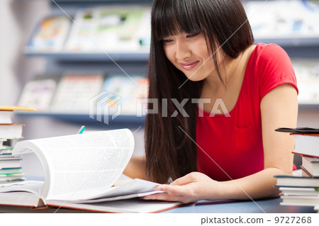 Beautiful female student in a library Beautiful female student in a library 9727268