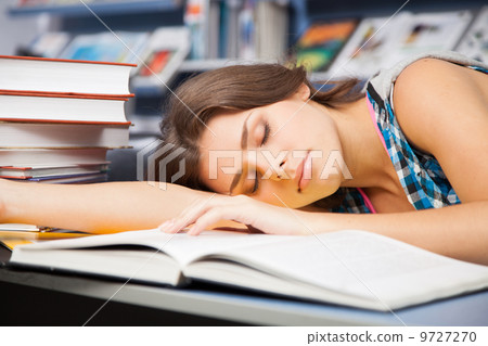 Beautiful female student in a library Beautiful female student in a library 9727270