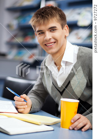 Handsome male student in a library Handsome male student in a library 9727272