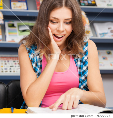 Beautiful female student in a university library Beautiful female student in a university library 9727274