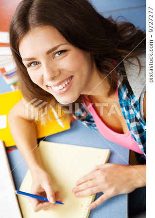 Beautiful female student in a library Beautiful female student in a library 9727277
