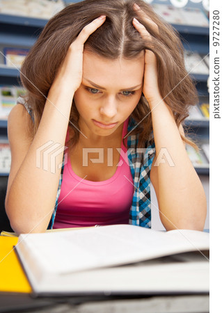 Stressed female student in a library Stressed female student in a library 9727280