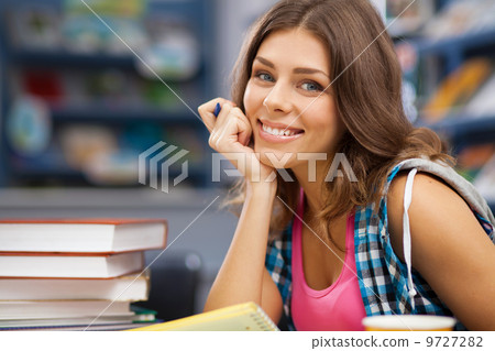 Beautiful female student in a library Beautiful female student in a library 9727282